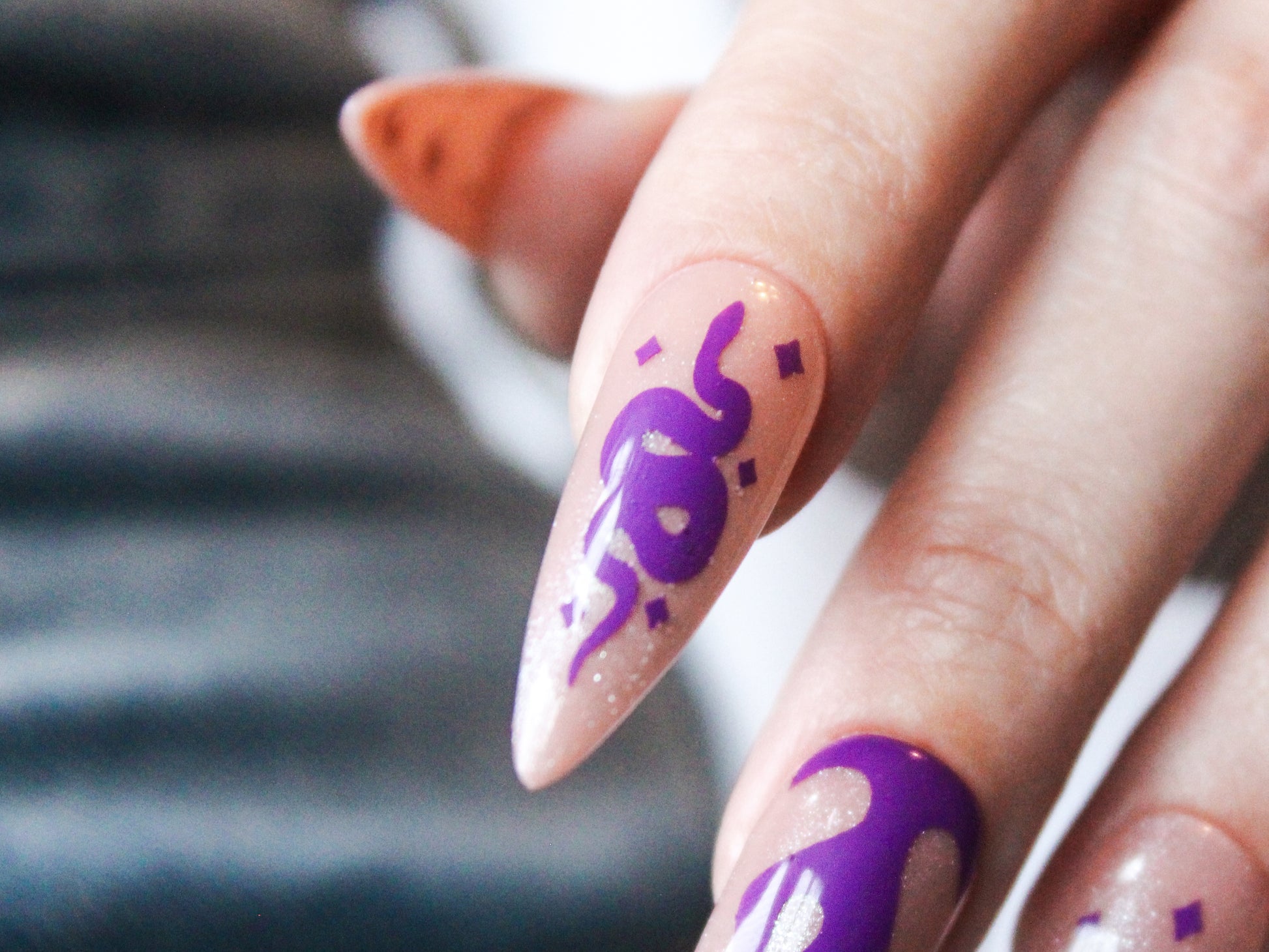 This showcases captivating details of our vinyl nail stickers with this close-up of an index finger. A sleek serpent design with matching glossy accents transforms the nail into a miniature work of art.